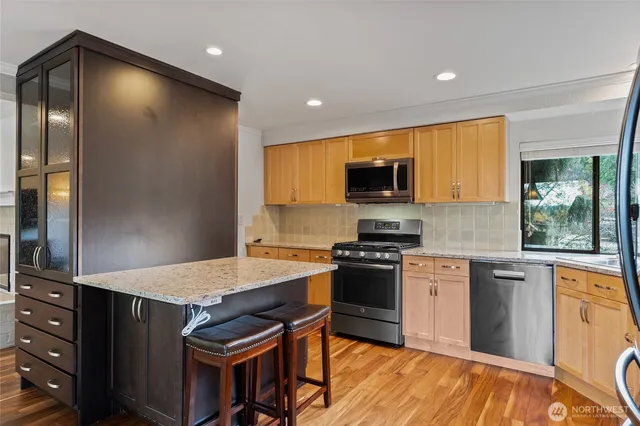 a kitchen with granite countertop a stove refrigerator and microwave