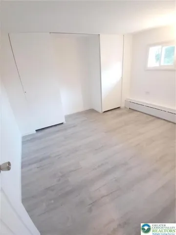 a view of a small space with wooden floor and a window