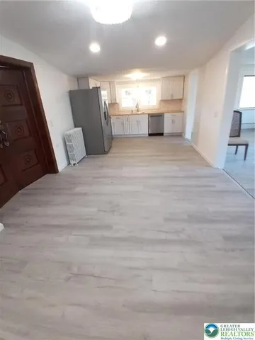 a view of a hallway with a couch and chandelier