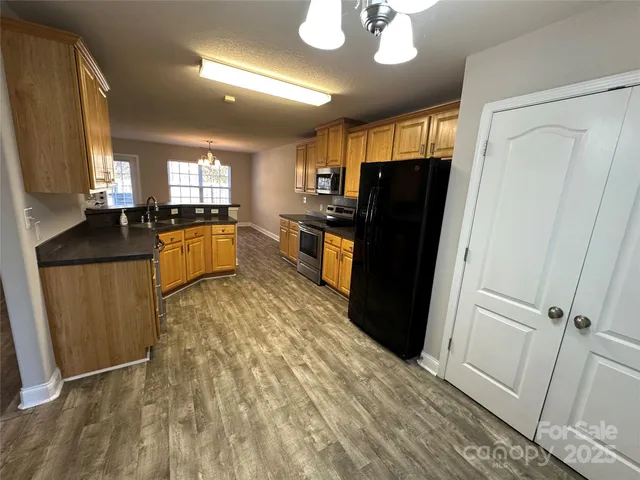 a kitchen with stainless steel appliances granite countertop a refrigerator and a sink