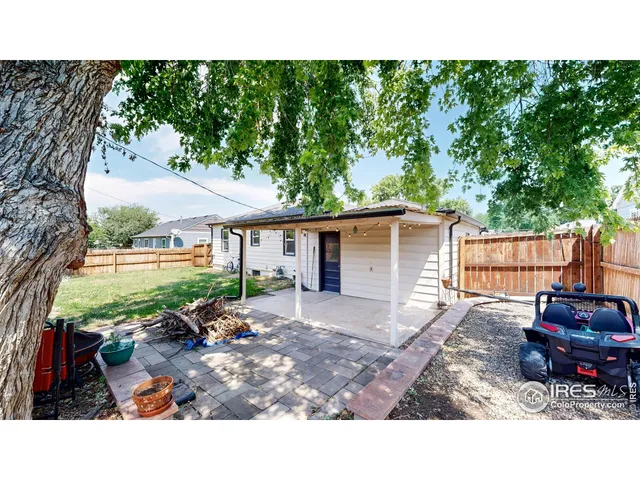 a backyard of a house with barbeque oven fire pit table and chairs