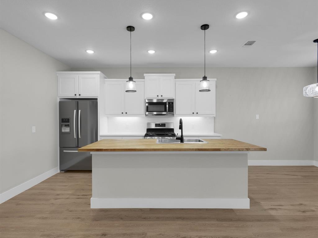 4905 Sweetbay Road Sherman, TX 75092 - Photo 5 of 26 a view of kitchen with kitchen island stainless steel appliances sink and stove