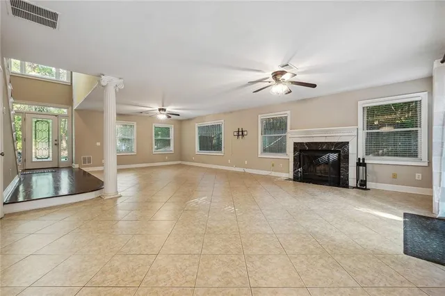 a view of an empty room with a window and kitchen view