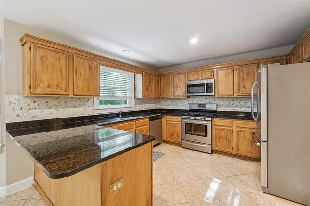 a kitchen with granite countertop white cabinets and refrigerator