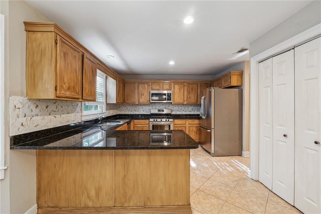 515 Spring Gate Lane Alpharetta, GA 30009 - Photo 15 of 36 a kitchen with granite countertop white cabinets and refrigerator