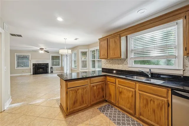 a kitchen with granite countertop a refrigerator and a sink