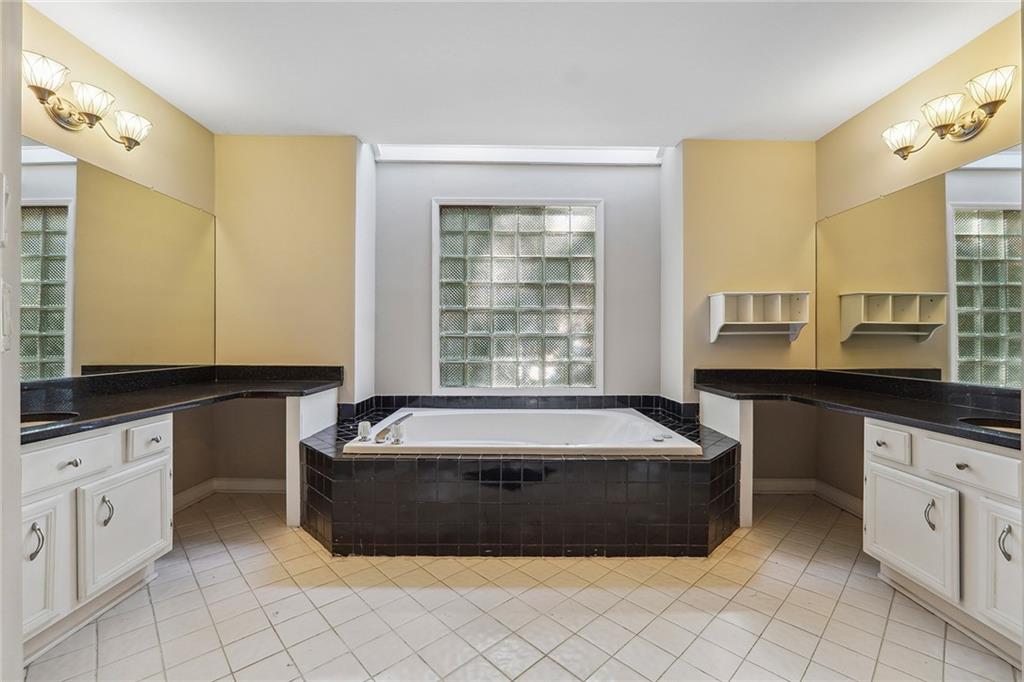 515 Spring Gate Lane Alpharetta, GA 30009 - Photo 20 of 36 a spacious bathroom with a granite countertop tub sink and mirror