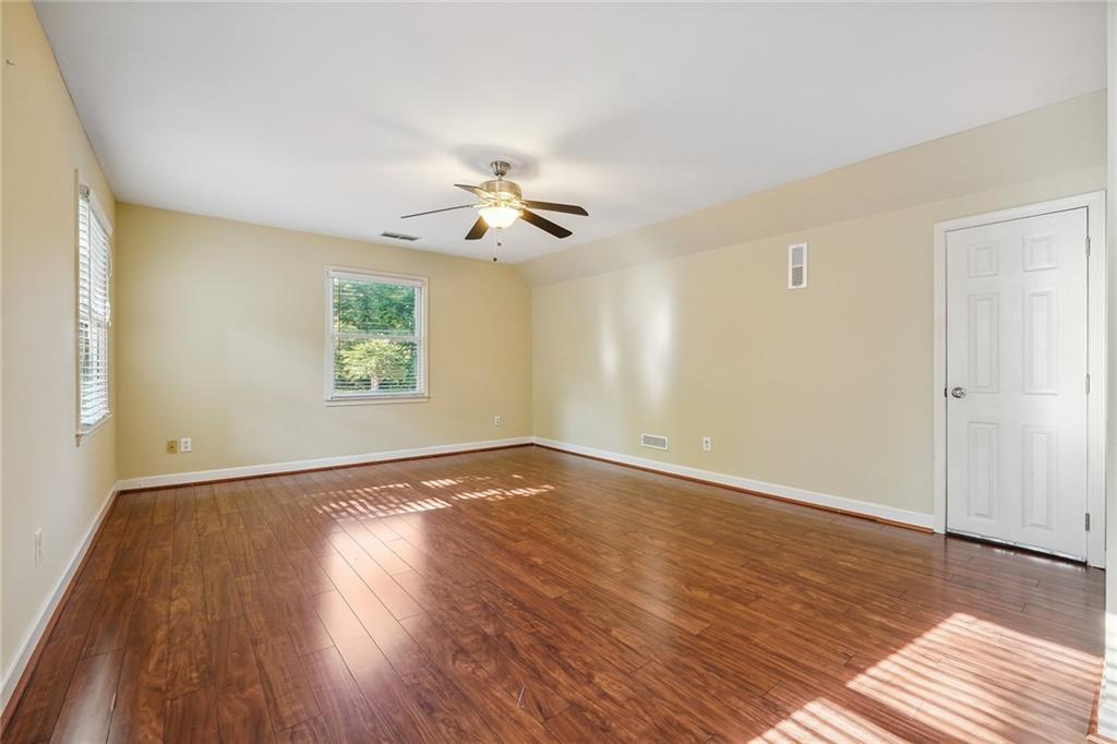 515 Spring Gate Lane Alpharetta, GA 30009 - Photo 24 of 36 a view of an empty room with a window and wooden floor