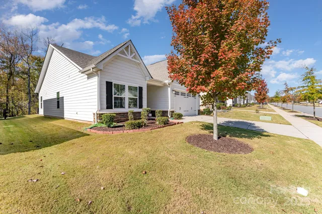 a view of a house with backyard and tree