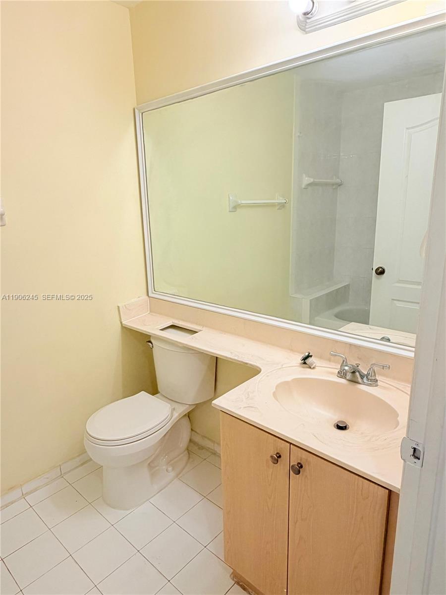 12635 Southwest 91st Street, Unit 211 Miami, FL 33186 - Photo 10 of 16 a bathroom with a sink a toilet and a mirror