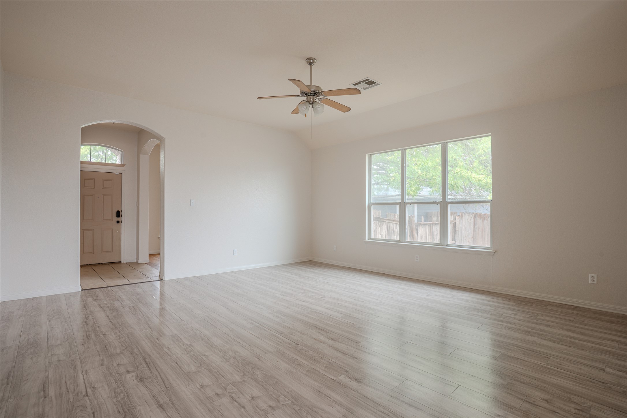 140 Dropper Kyle, TX 78640 - Photo 6 of 30 an empty room with wooden floor ceiling fan and windows