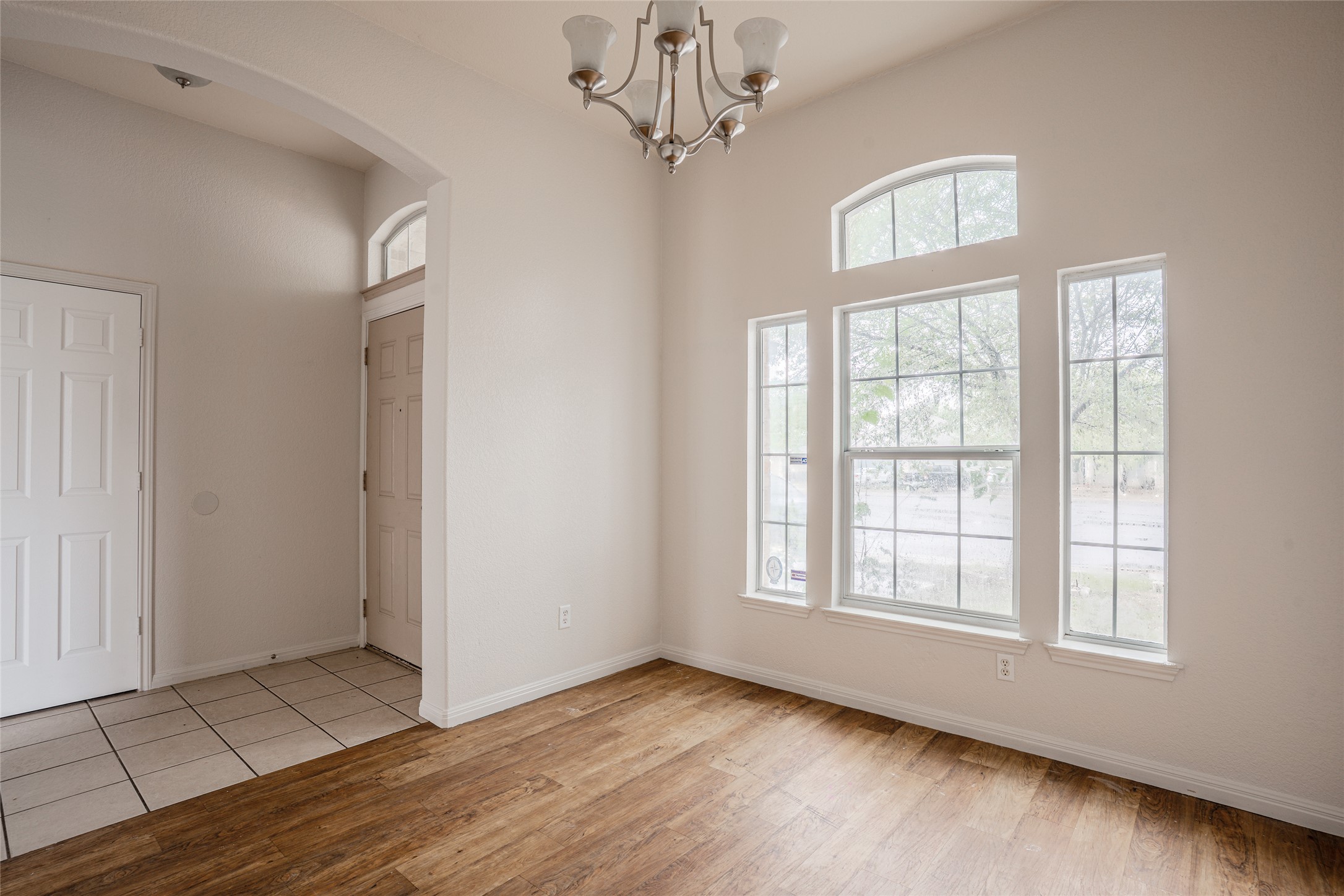 140 Dropper Kyle, TX 78640 - Photo 7 of 30 an empty room with wooden floor chandelier and windows