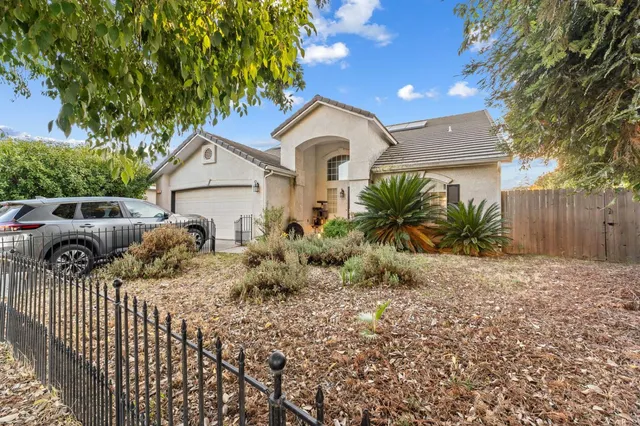 a front view of house with yard and trees in the background