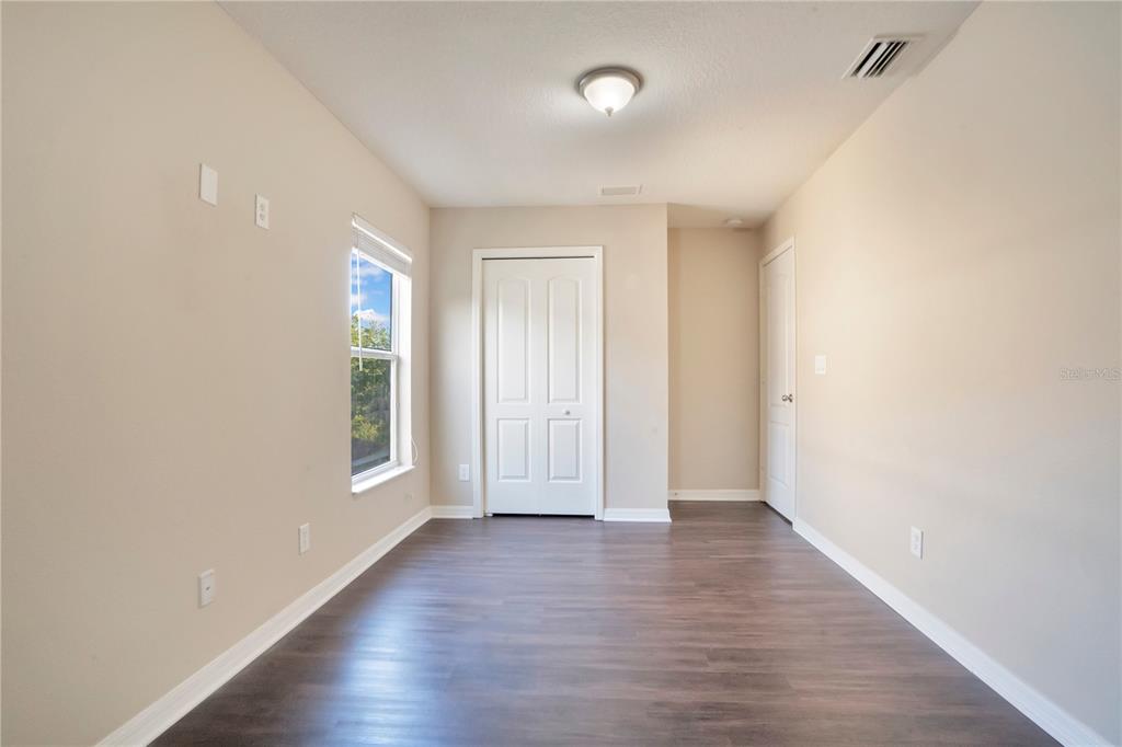 15031 Skip Jack Loop Lakewood Ranch, FL 34202 - Photo 20 of 27 an empty room with wooden floor and windows