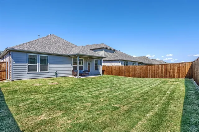a view of a backyard with table and chairs under an umbrella