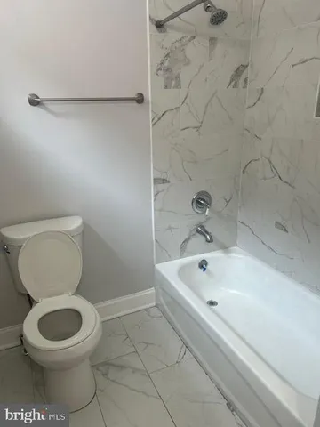 a white toilet sitting next to a bath tub