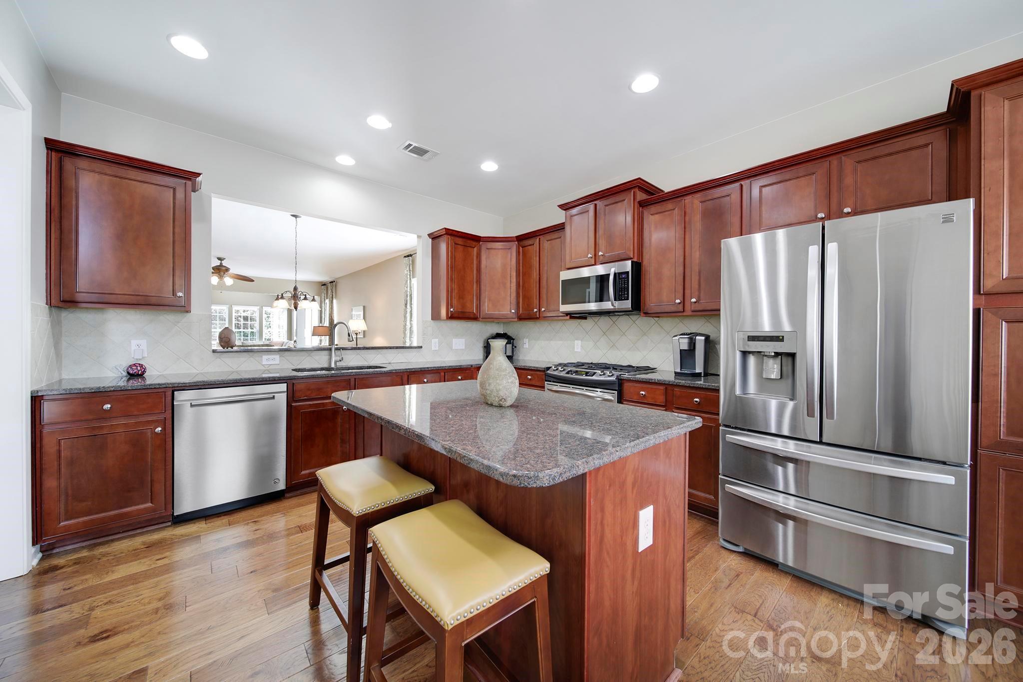 55414 Derringer Avenue Fort Mill, SC 29707 - Photo 5 of 45 a kitchen with stainless steel appliances granite countertop a refrigerator a sink a stove a microwave and wooden cabinets