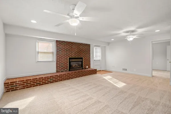 an empty room with windows and fireplace