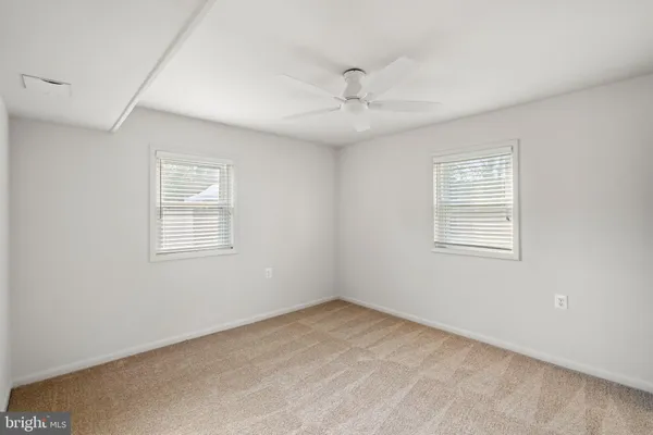 an empty room with a window and ceiling fan