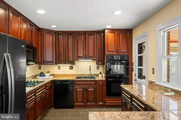 a kitchen with granite countertop stainless steel appliances and wooden cabinets