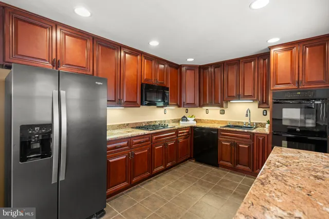 a kitchen with granite countertop stainless steel appliances and wooden cabinets