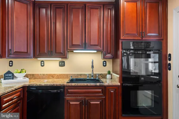 a kitchen with granite countertop wooden cabinets and a sink