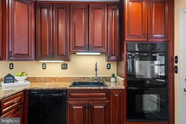a kitchen with granite countertop wooden cabinets and a sink