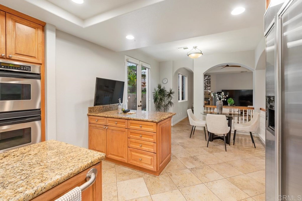 339 Hestia Way Encinitas, CA 92024 - Photo 21 of 33 a large kitchen with kitchen island granite countertop wooden cabinets and stainless steel appliances
