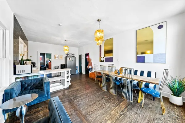 a living room with furniture and a dining table with wooden floor
