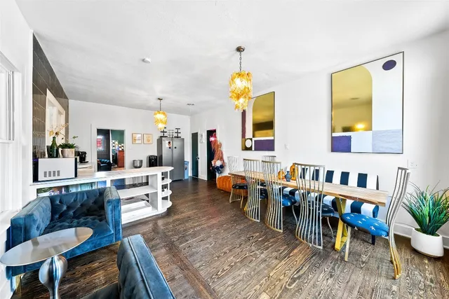 a living room with furniture and a dining table with wooden floor