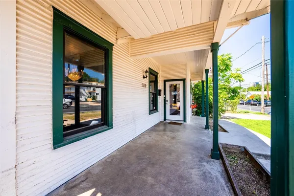 a view of a hallway with wooden floor and a yard
