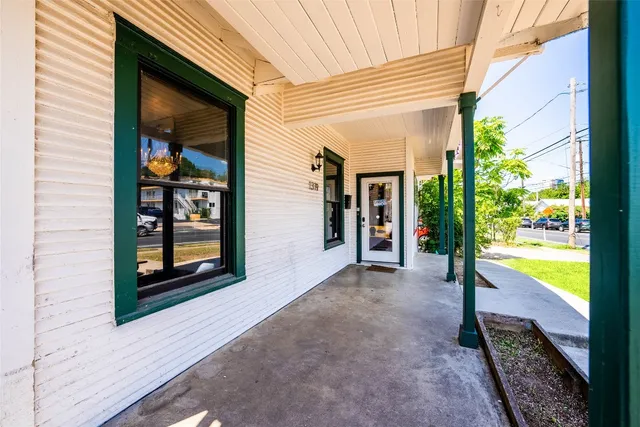 a view of a hallway with wooden floor and a yard