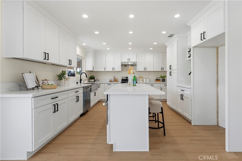 645 Lancer Lane Corona, CA 92879 - Photo 14 of 69 a kitchen with white cabinets and stainless steel appliances
