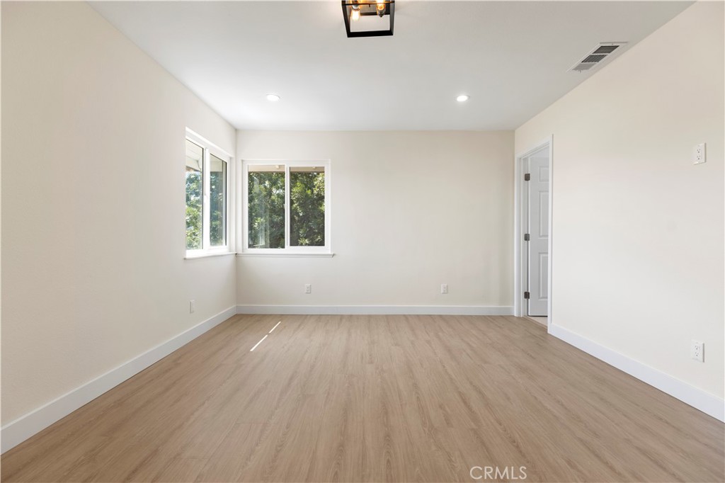 645 Lancer Lane Corona, CA 92879 - Photo 28 of 69 an empty room with wooden floor and windows