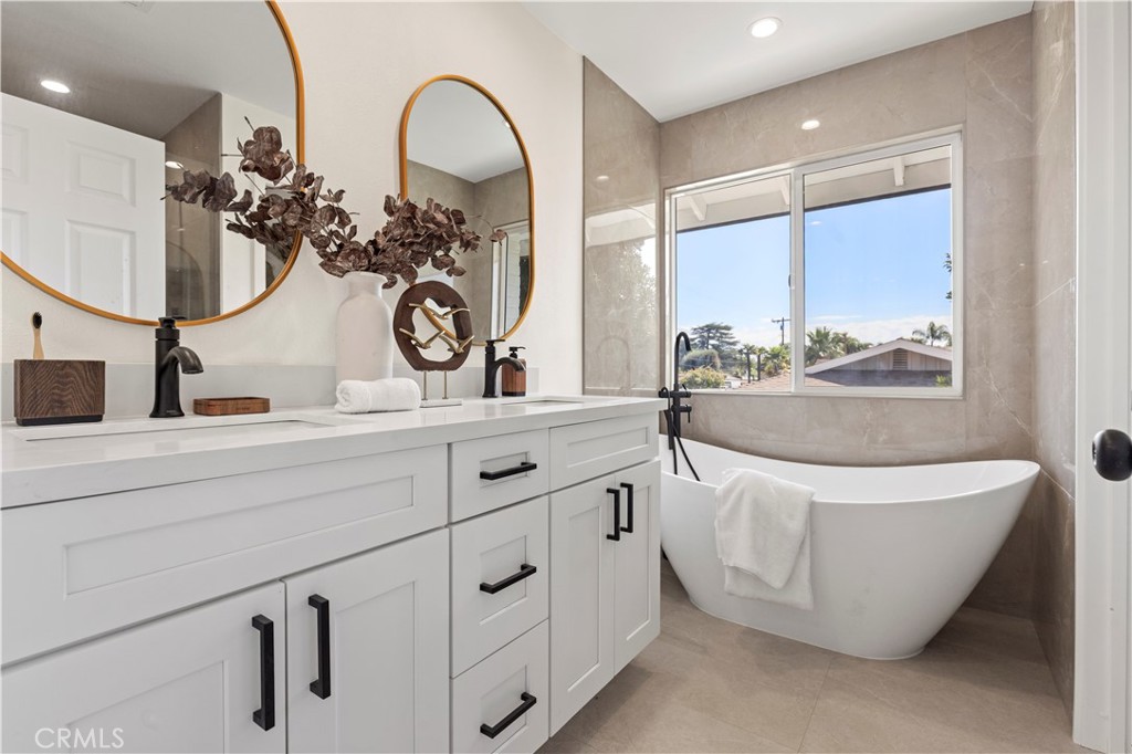 645 Lancer Lane Corona, CA 92879 - Photo 39 of 69 a bathroom with a double vanity sink a mirror and a bathtub