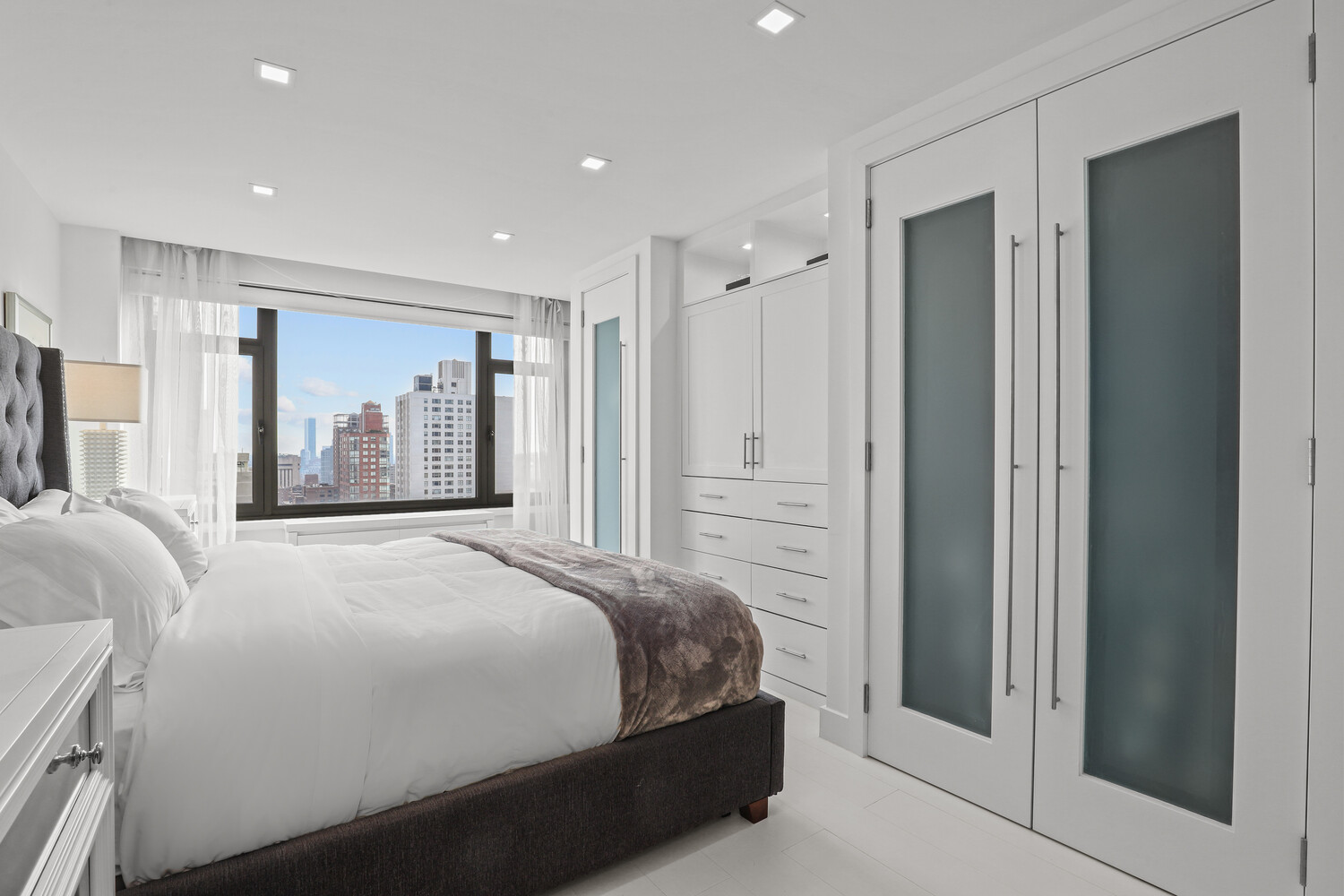 160 East 65th Street, Unit 26B Manhattan, NY 10065 - Photo 6 of 12 a bedroom with a large bed and a mirror