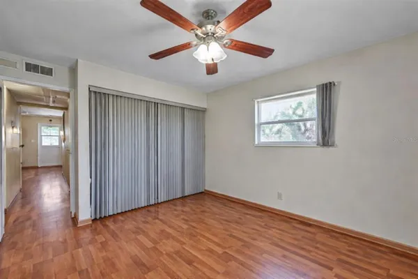 a view of an empty room with window and wooden floor