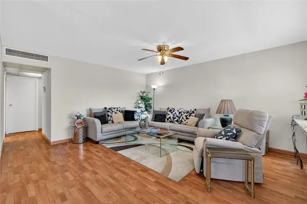 a living room with furniture and a wooden floor
