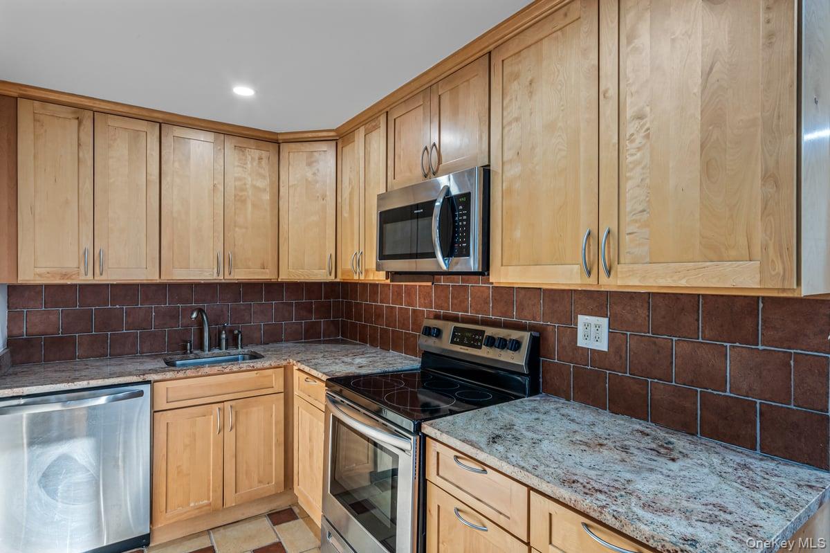 168-11 12th Avenue, Unit 3D Queens, NY 11357 - Photo 6 of 21 a kitchen with granite countertop a sink a stove and cabinets