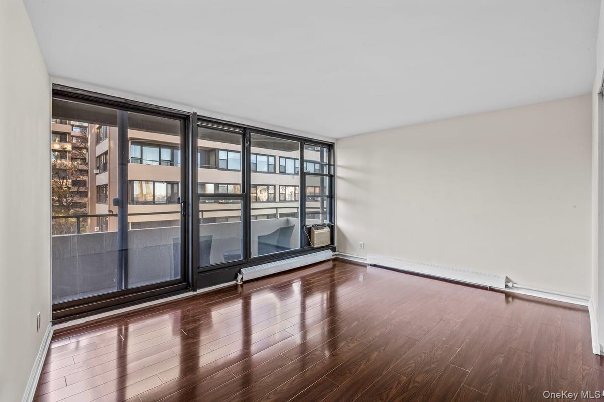 168-11 12th Avenue, Unit 3D Queens, NY 11357 - Photo 8 of 21 wooden floor in an empty room with a window