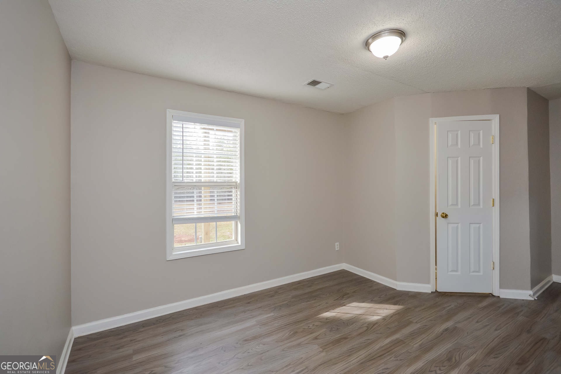 110 Tara Way Covington, GA 30016 - Photo 14 of 17 an empty room with wooden floor and windows