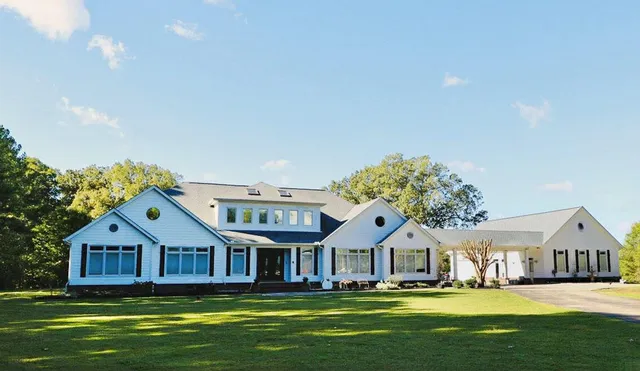 a front view of a house with a garden and trees