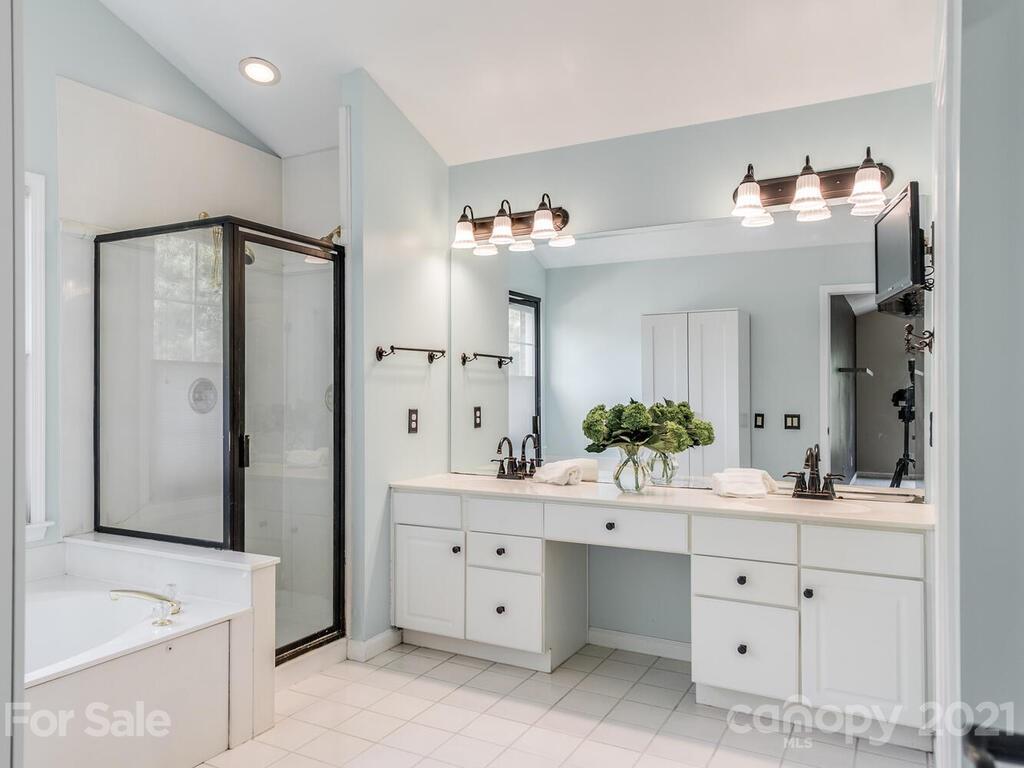 5530 Piper Glen Drive Charlotte, NC 28277 - Photo 21 of 35 a spacious bathroom with a double vanity sink a mirror and a bathtub