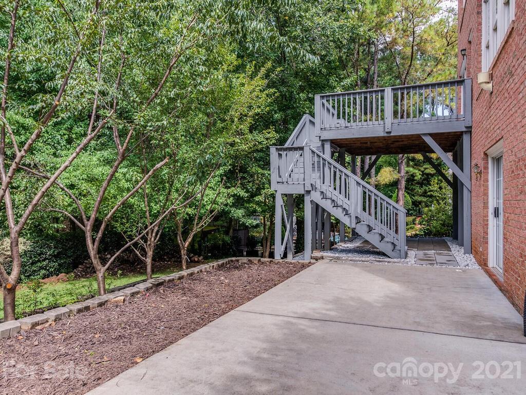5530 Piper Glen Drive Charlotte, NC 28277 - Photo 32 of 35 a view of a wooden deck with large trees and a small yard