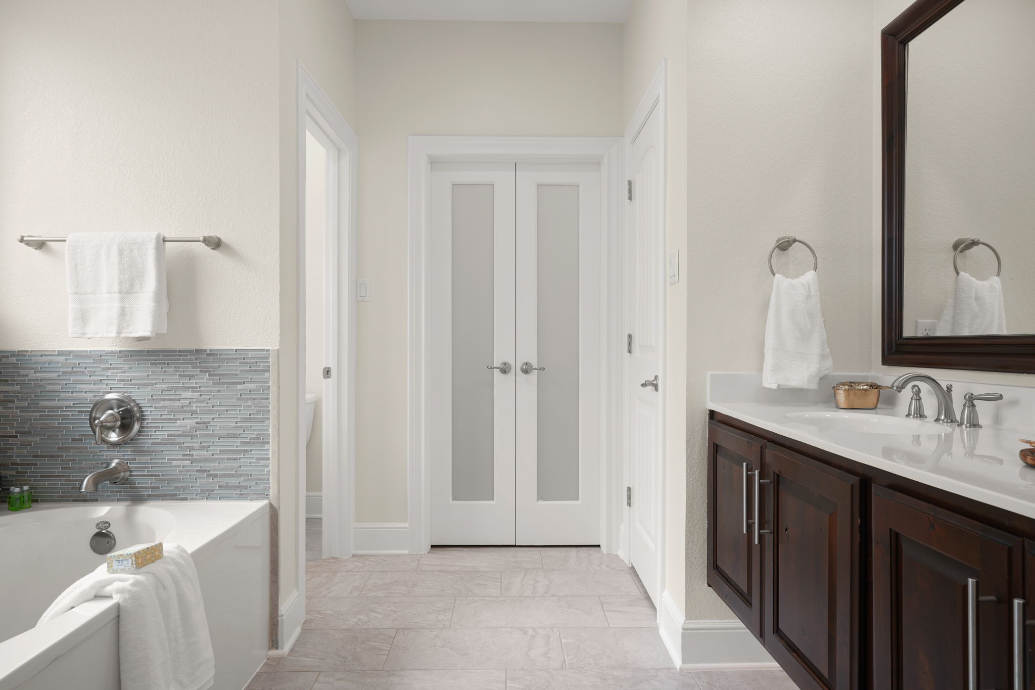 440 Cherokee Rose Circle Georgetown, TX 78626 - Photo 28 of 39 Bright, naturally illuminated primary bathroom with a spacious soaking tub and a sleek floating vanity.