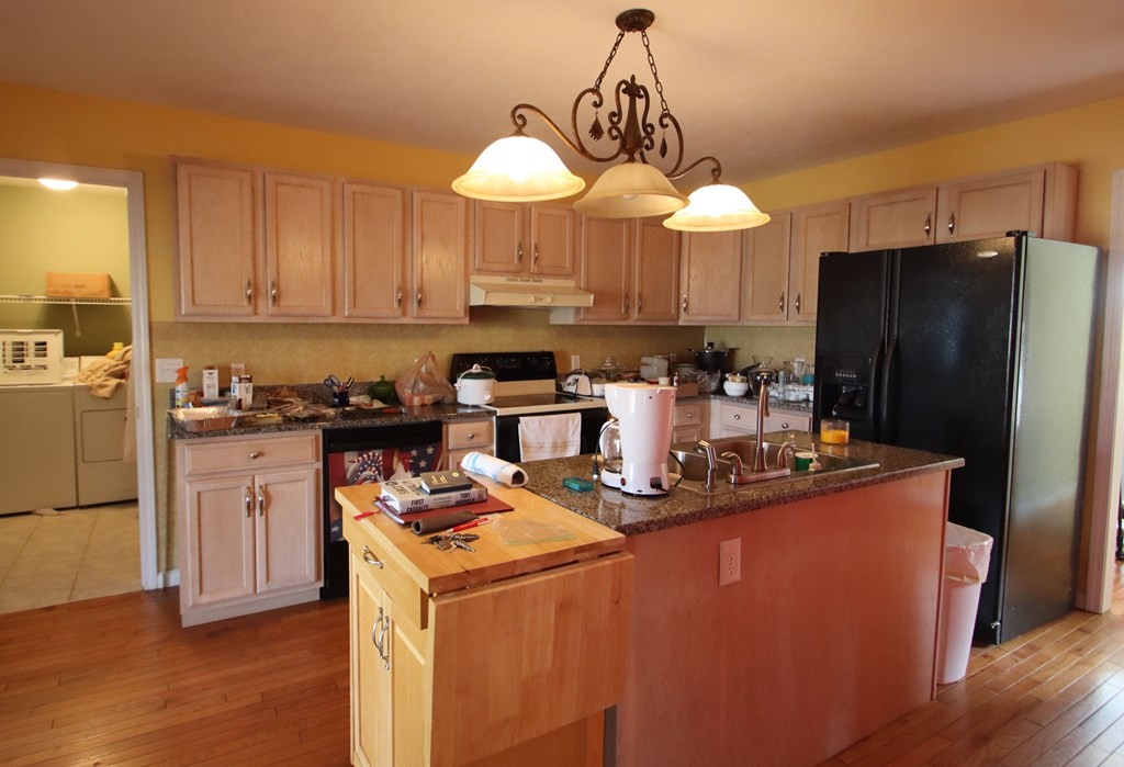 154 Charleston Road Cookeville, TN 38506 - Photo 9 of 23 a kitchen with stainless steel appliances granite countertop a refrigerator a sink dishwasher a stove and a dining table with wooden floor