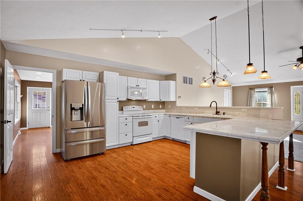 90 Coffeys Crossing Road Washington, PA 15301 - Photo 7 of 50 a kitchen with stainless steel appliances granite countertop a refrigerator a sink dishwasher a stove and white countertops with wooden floor