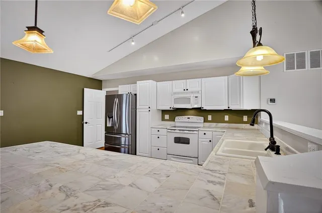 a kitchen with stainless steel appliances a refrigerator sink and stove