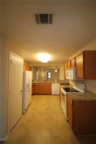 a large kitchen with a large counter top appliances and cabinets