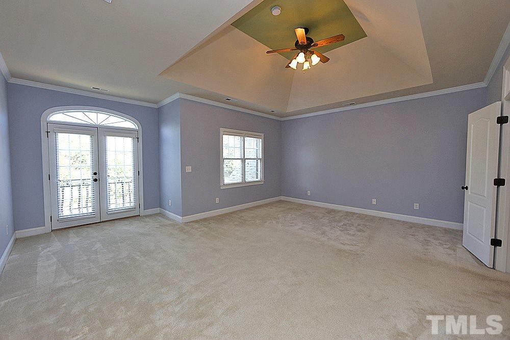 5214 Landguard Drive Raleigh, NC 27613 - Photo 12 of 20 an empty room with chandelier fan and windows